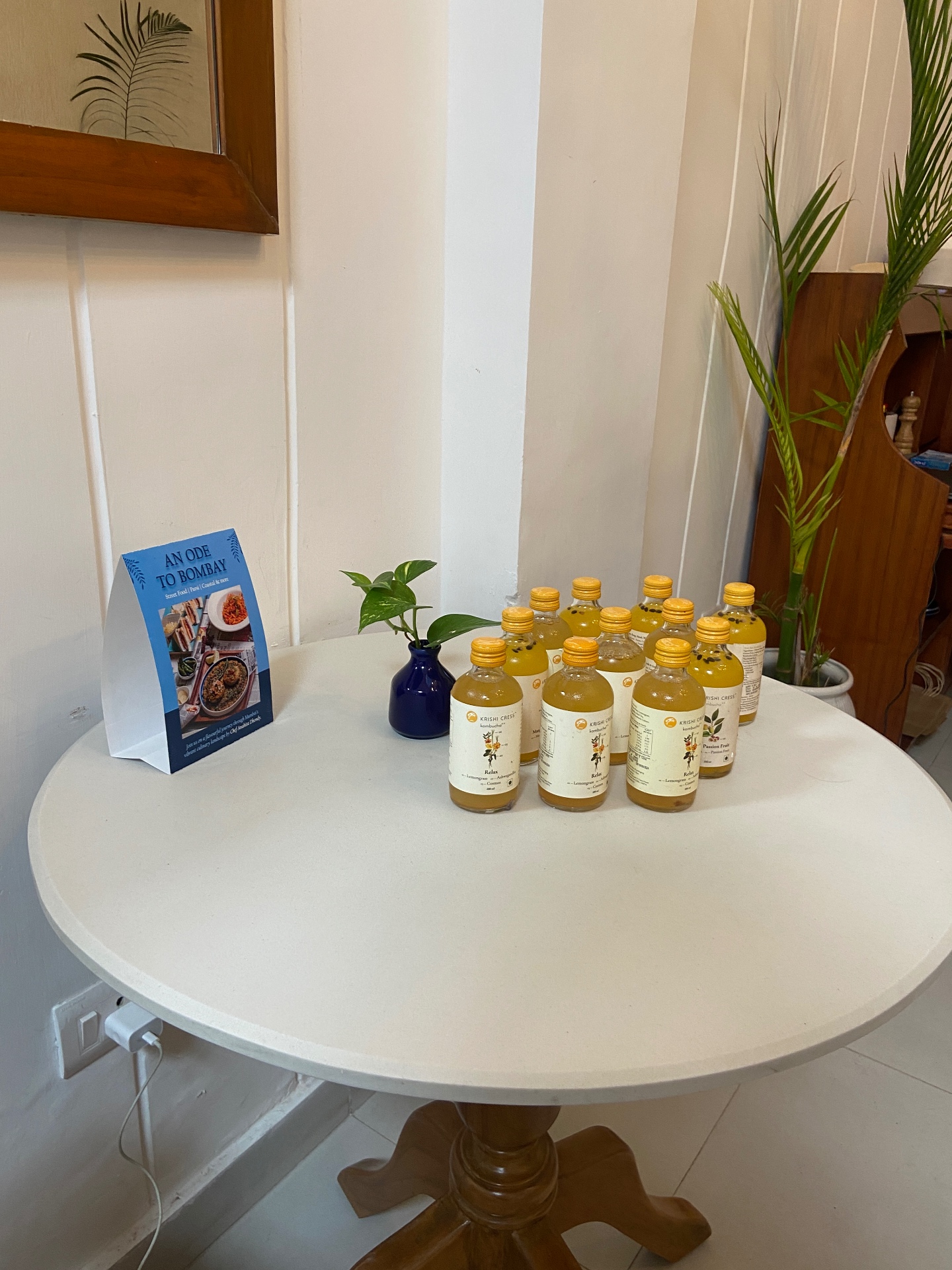 Krishi Cress kombucha bottles styled on a café table
